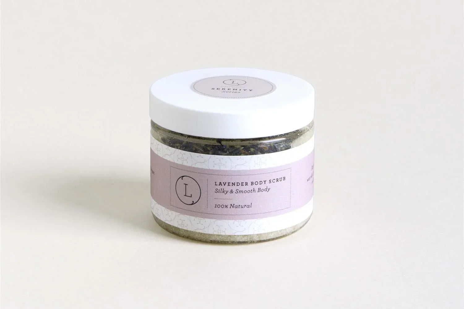 Jar of lavender body scrub with white lid and purple label on light background