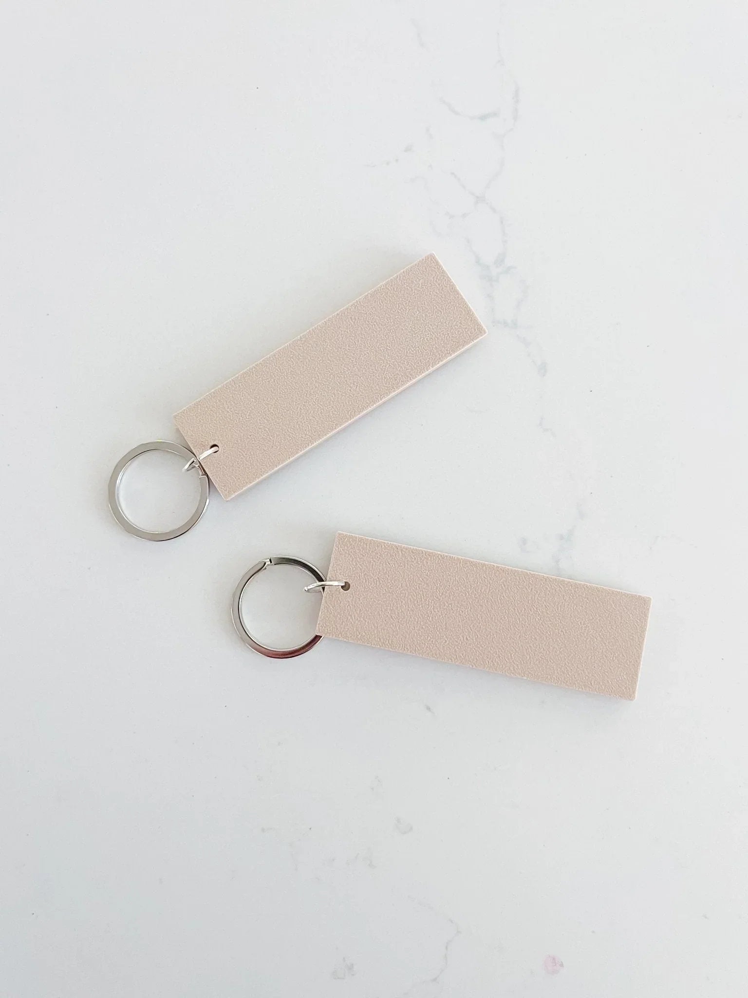 Minimalist blush pink rectangular keychains on white marble background, Qu!rk Boutique gift