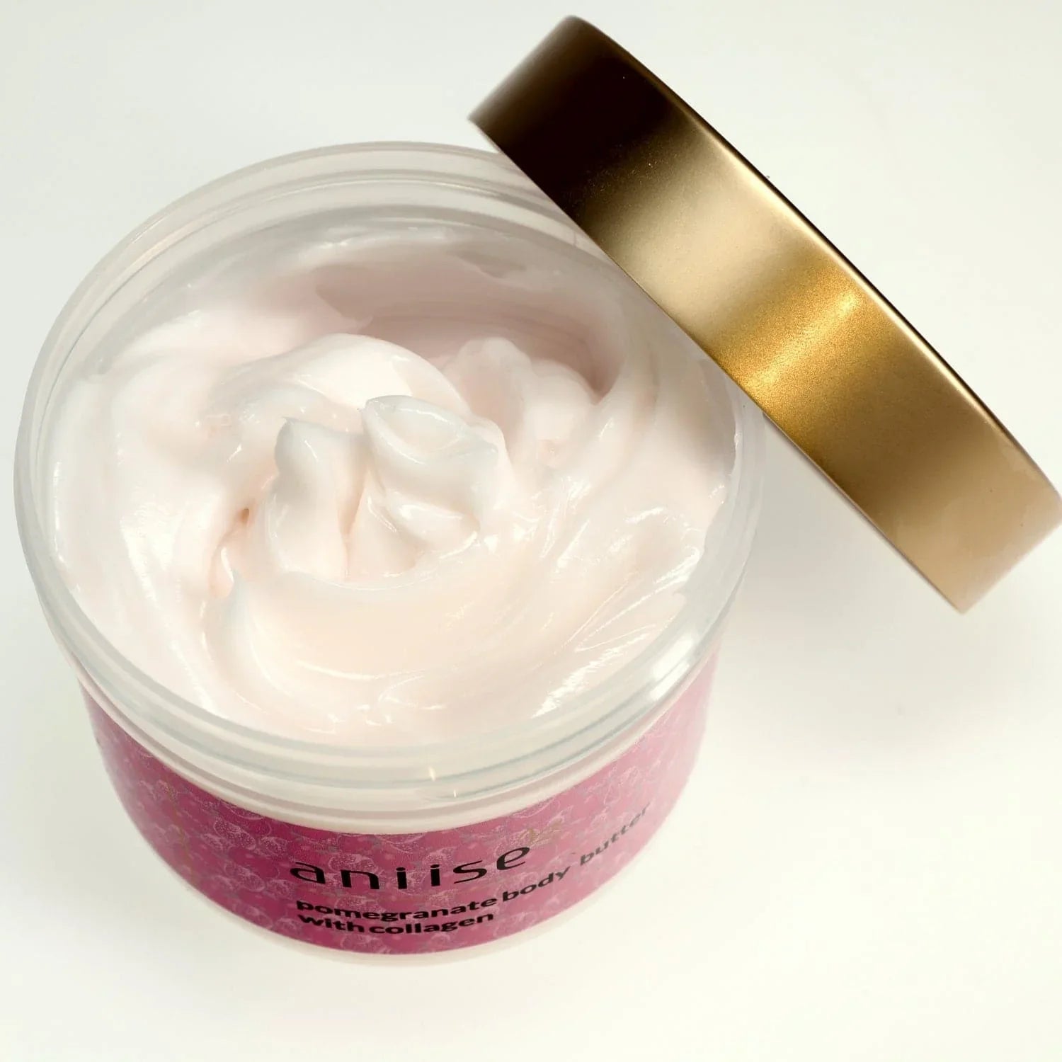 Open jar of Aniise pomegranate body butter cream with collagen and gold lid on white background