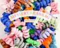 Colorful assortment of baby critter toys labeled 'Mystery Grab Bag' at Qu!rk Boutique