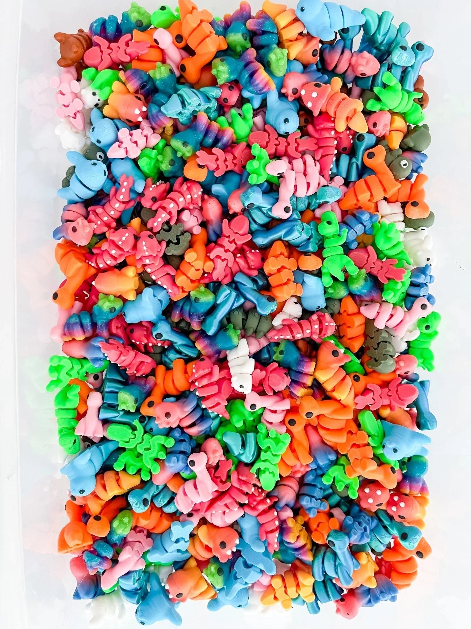 Colorful mini animal-shaped charms in a rectangular pile, featured at Qu!rk Boutique.