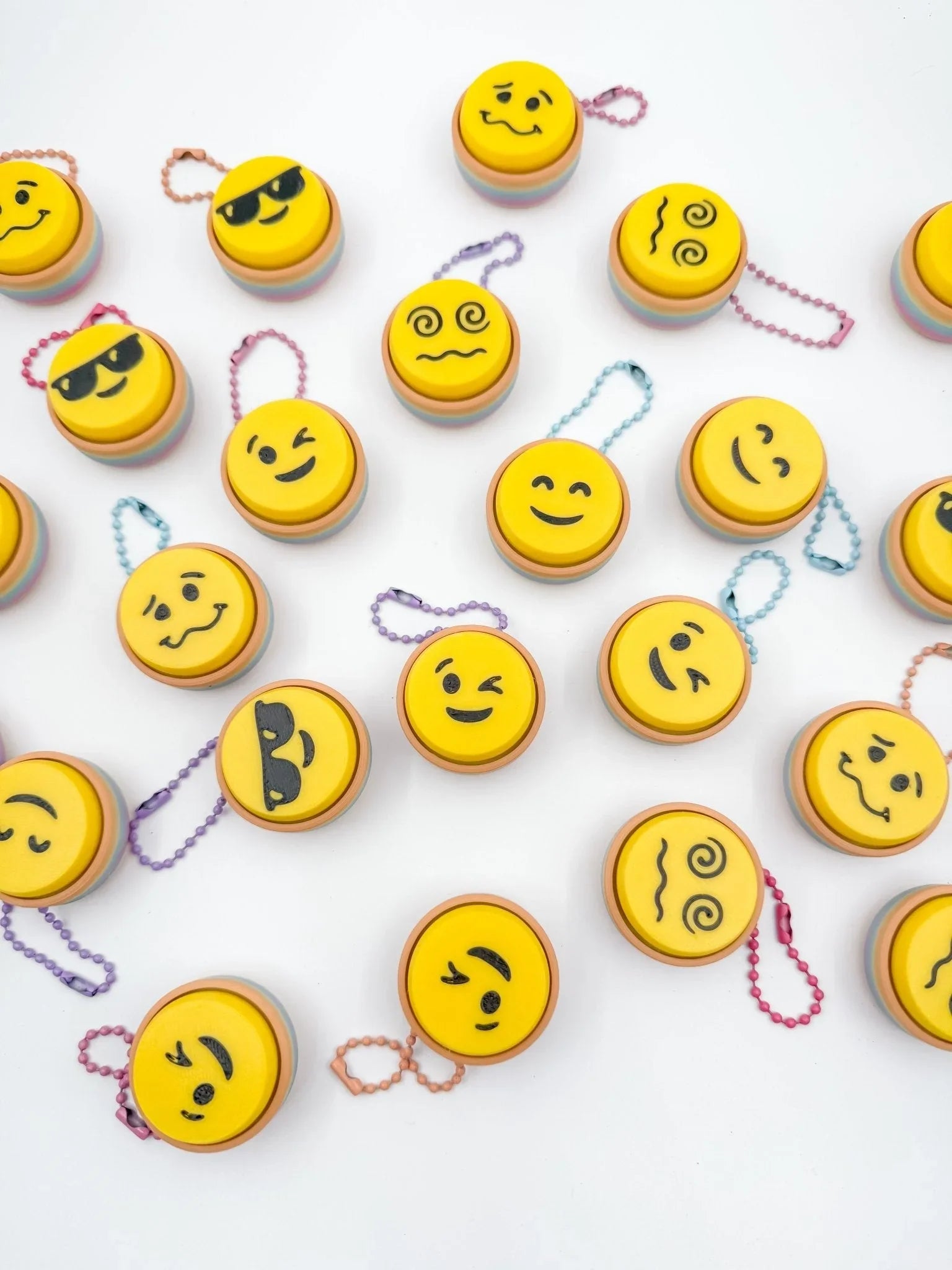 Assorted emoji face keyboard clickers with colorful chains on white background, Qu!rk Boutique