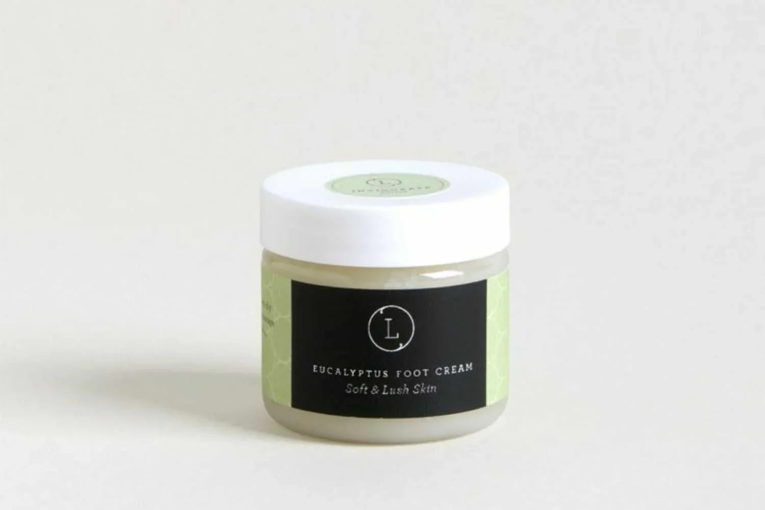 Jar of eucalyptus foot cream with white lid and black label for soft, lush skin