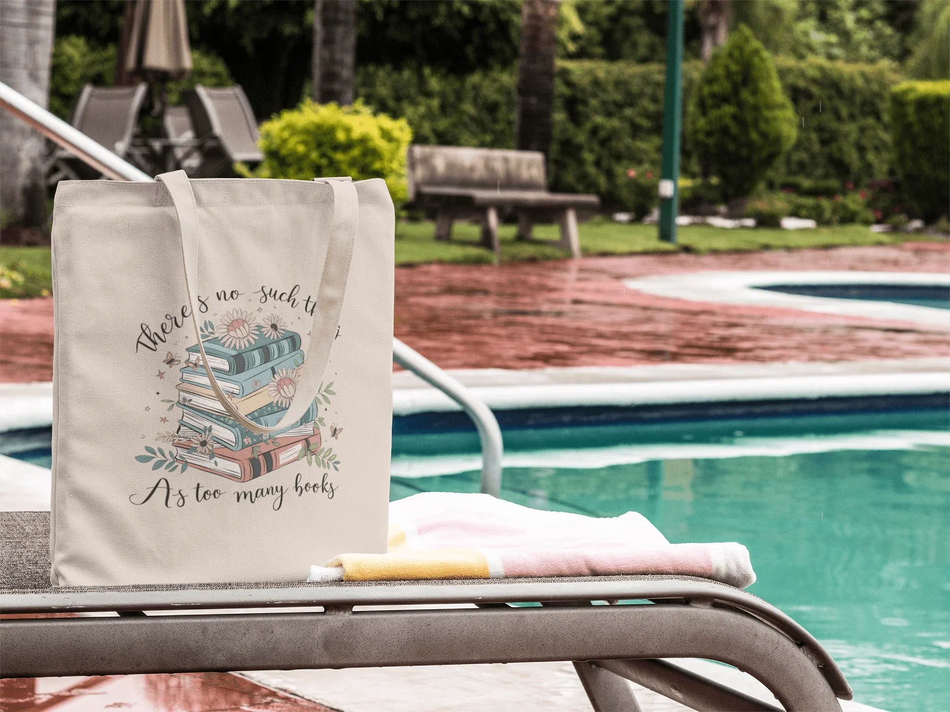 Canvas tote bag with books and flowers design, text 'There's no such thing as too many books' by a poolside