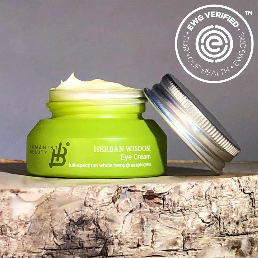 Herban Wisdom Eye Cream in green jar, sustainably packaged, with EWG Verified badge, on wood