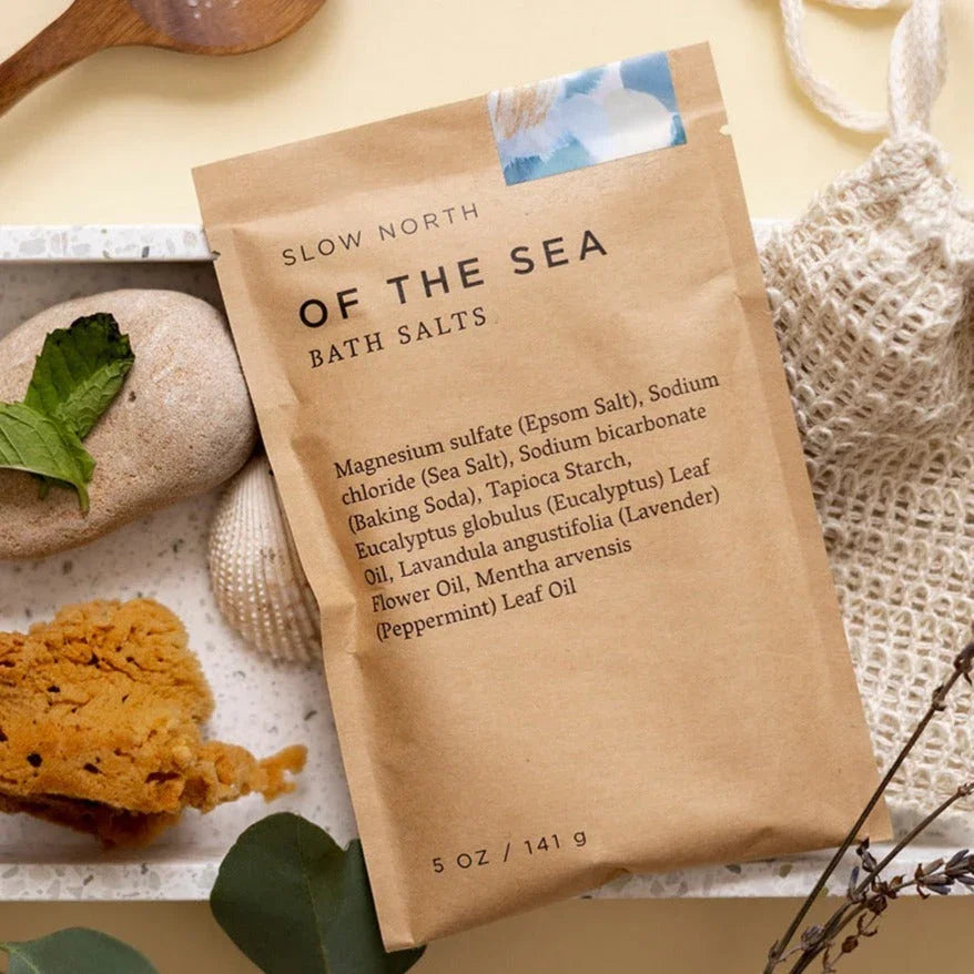 Slow North Of The Sea bath salts pouch on a tray with natural sponge, mint, and stones