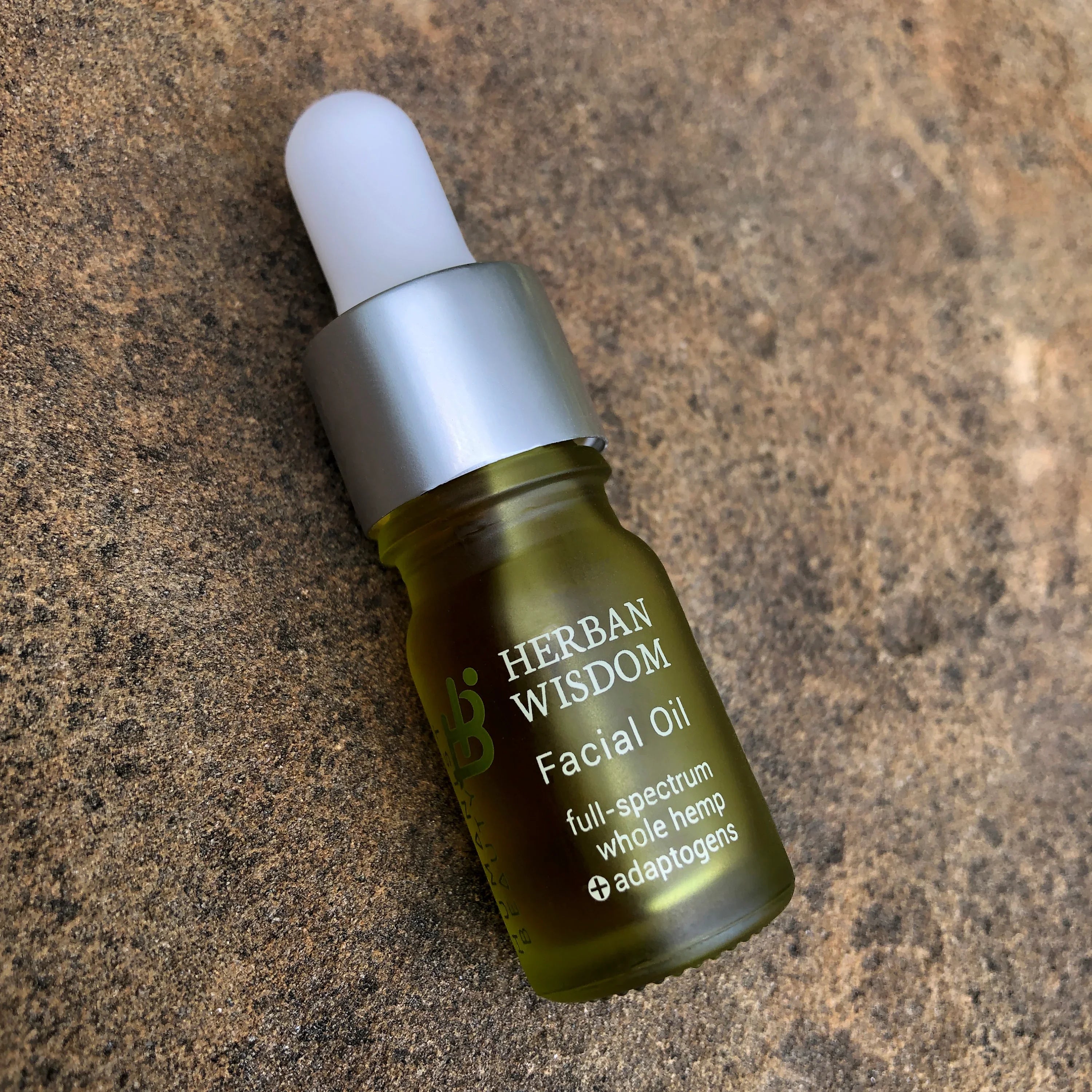 Herban Wisdom full-spectrum whole hemp facial oil with adaptogens in green glass dropper bottle