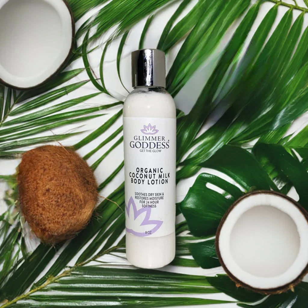 Glimmer Goddess organic coconut milk body lotion bottle with fresh coconuts and palm leaves.