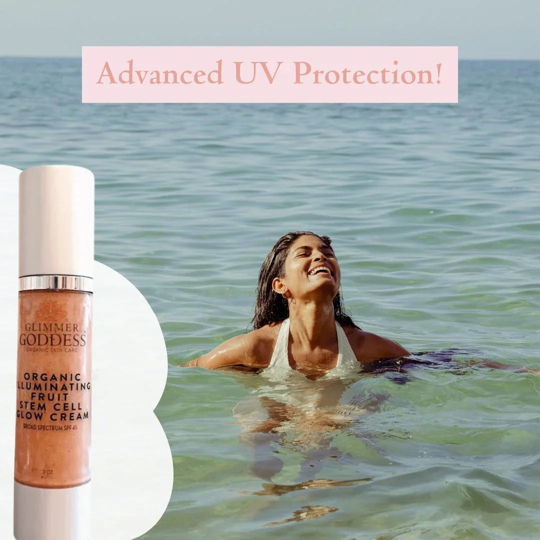 Woman in ocean wearing white swimsuit, smiling with sun protection, next to Glimmer Goddess Organic Illuminating Fruit Stem Cell Glow Cream SPF 45 bottle, text says Advanced UV Protection.