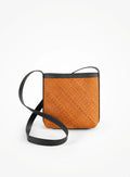 Woven tan crossbody bag with black trim and strap, spring collection at Qu!rk Boutique