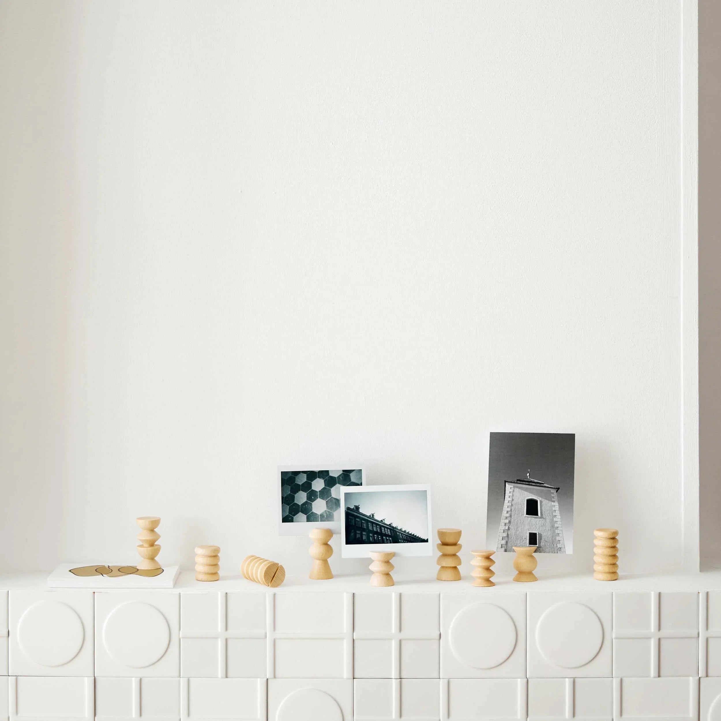 Minimalist wooden postcard stands with photos on a modern white textured mantel, Qu!rk Boutique home decor