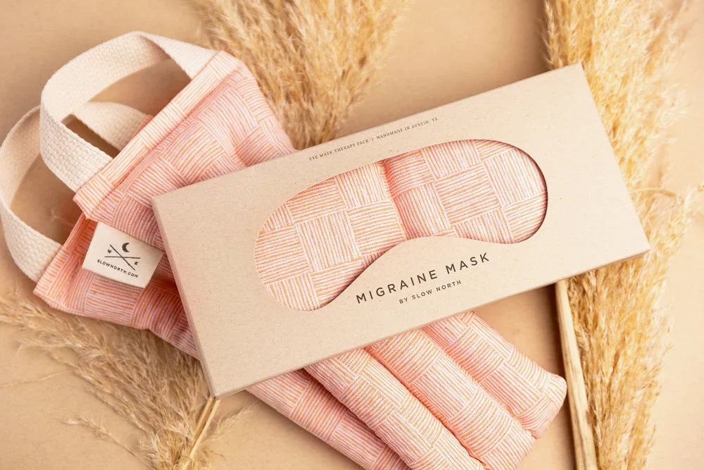 Pink geometric patterned migraine mask and eye therapy pack with natural pampas grass background