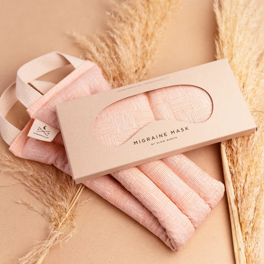 Pink patterned migraine mask and eye mask therapy pack with natural pampas grass on beige background