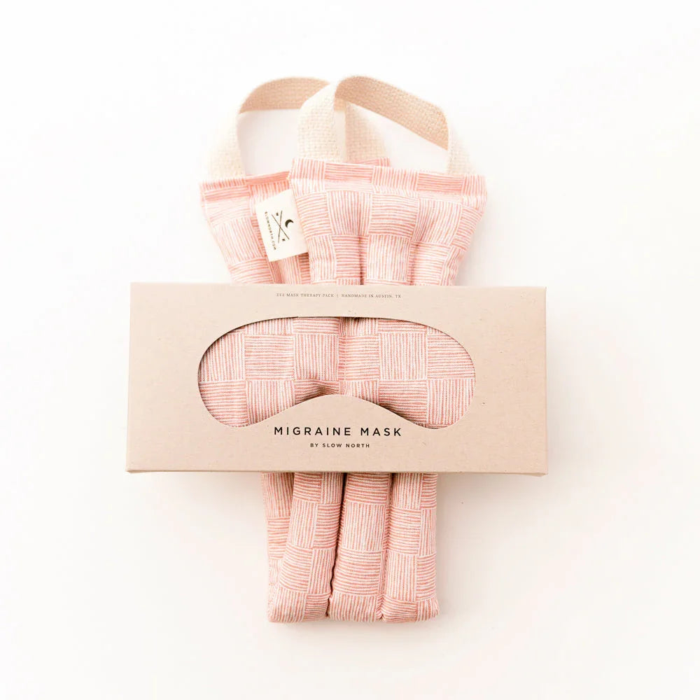 Pink patterned migraine mask with handles packaged in beige box by Slow North