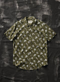 Olive green button-up shirt with white skull, dagger, and rose tattoo print, flat lay