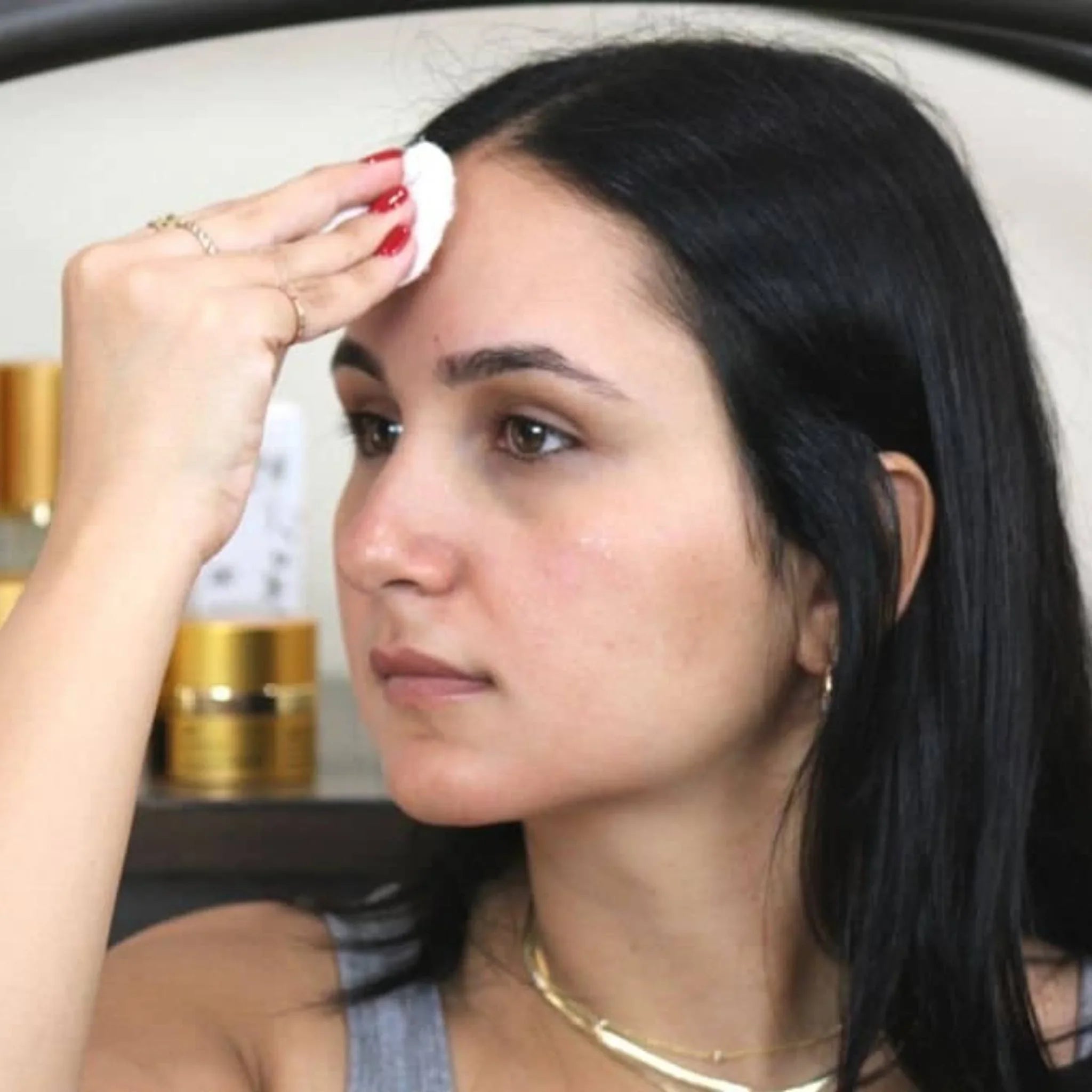 Woman applying cucumber extract facial toner with cotton pad, skincare routine, Qu!rk Boutique