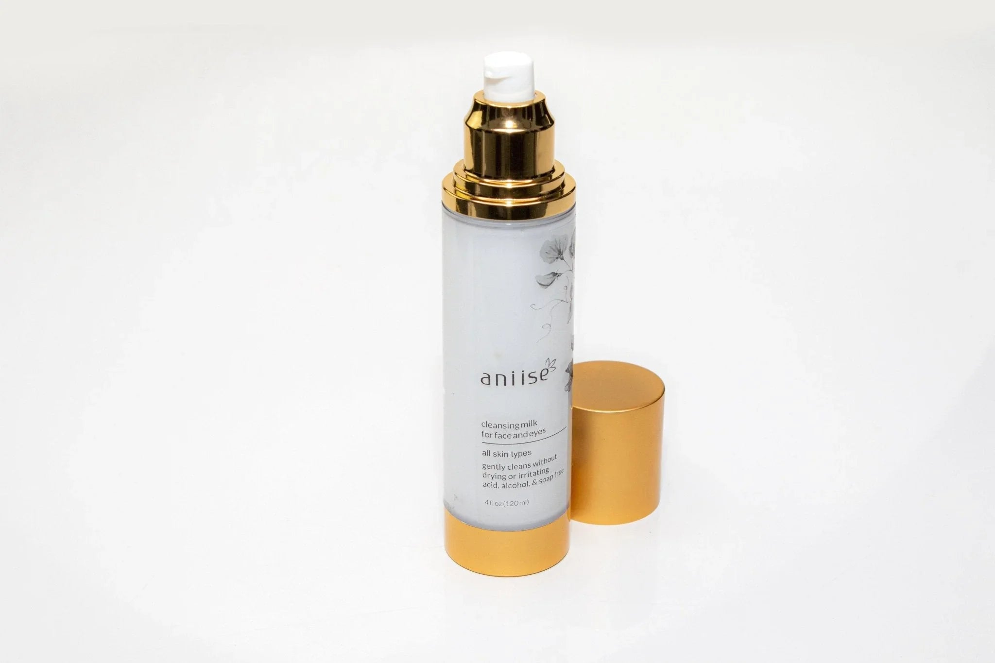 Aniise cleansing milk for face and eyes in a gold and white bottle, skincare product on white background.