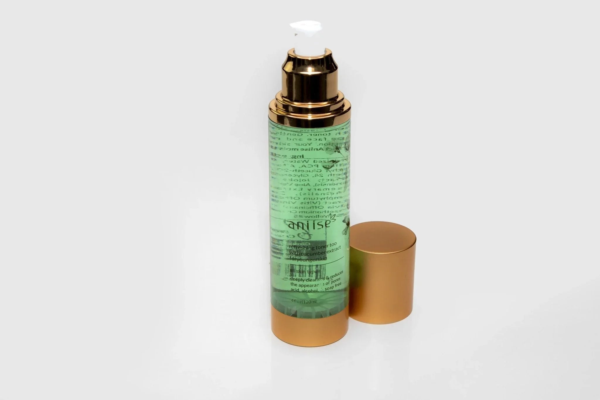 Green skincare toner bottle with gold cap, minimalistic background, Qu!rk Boutique gift shop