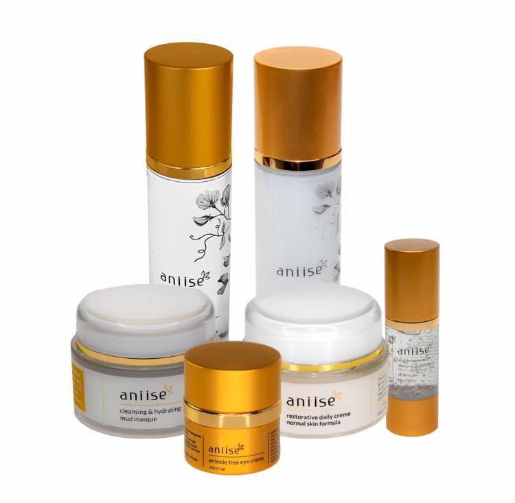 Anise skincare collection with gold lids, hydrating creams and serums, boutique beauty set.
