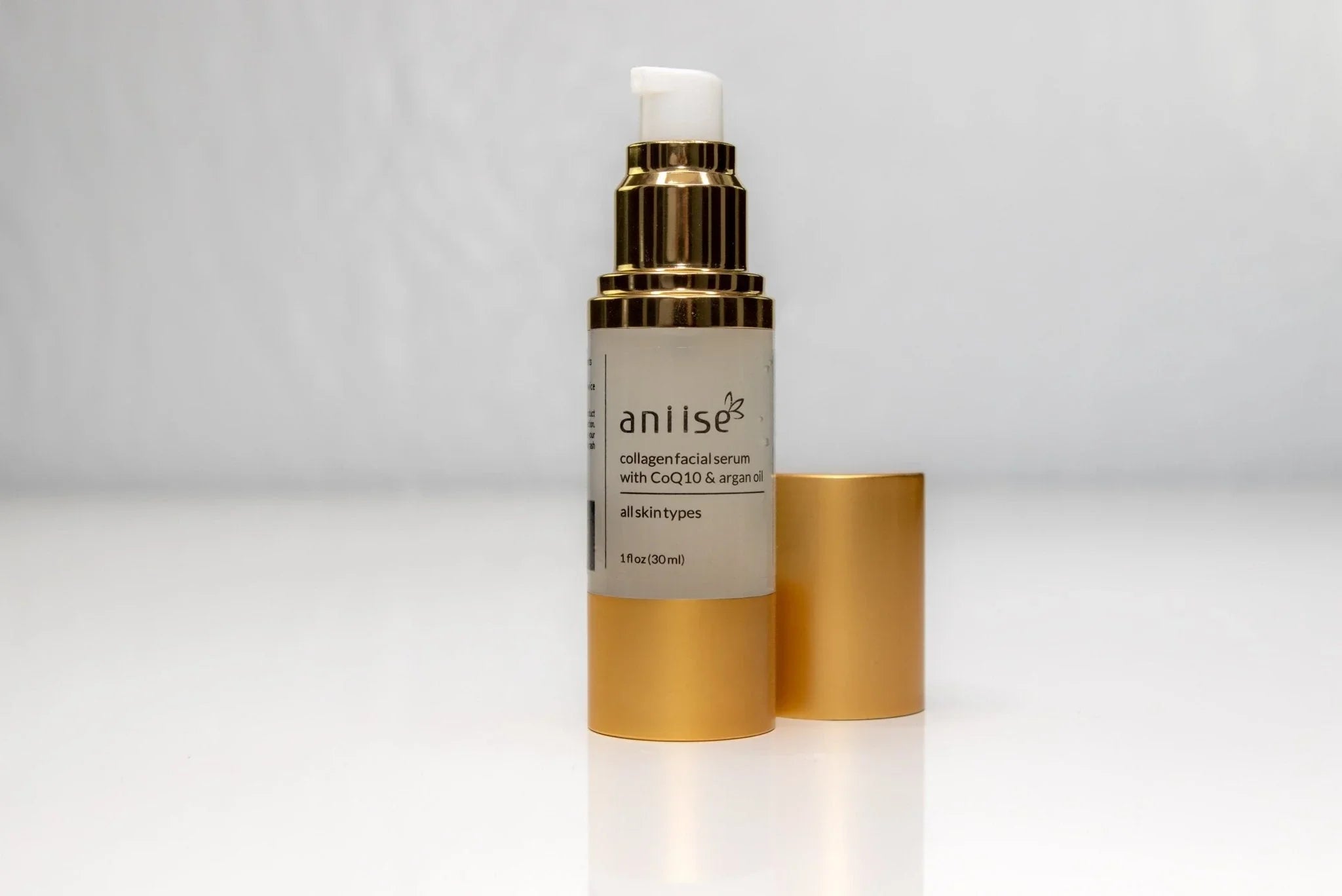 Anise collagen facial serum with CoQ10 and argan oil in gold bottle on white background