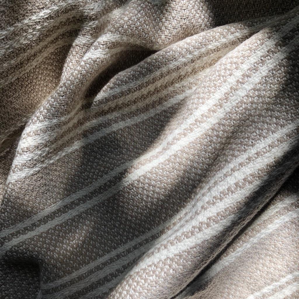 Neutral striped handwoven textile with natural fibers, featured at Qu!rk Boutique