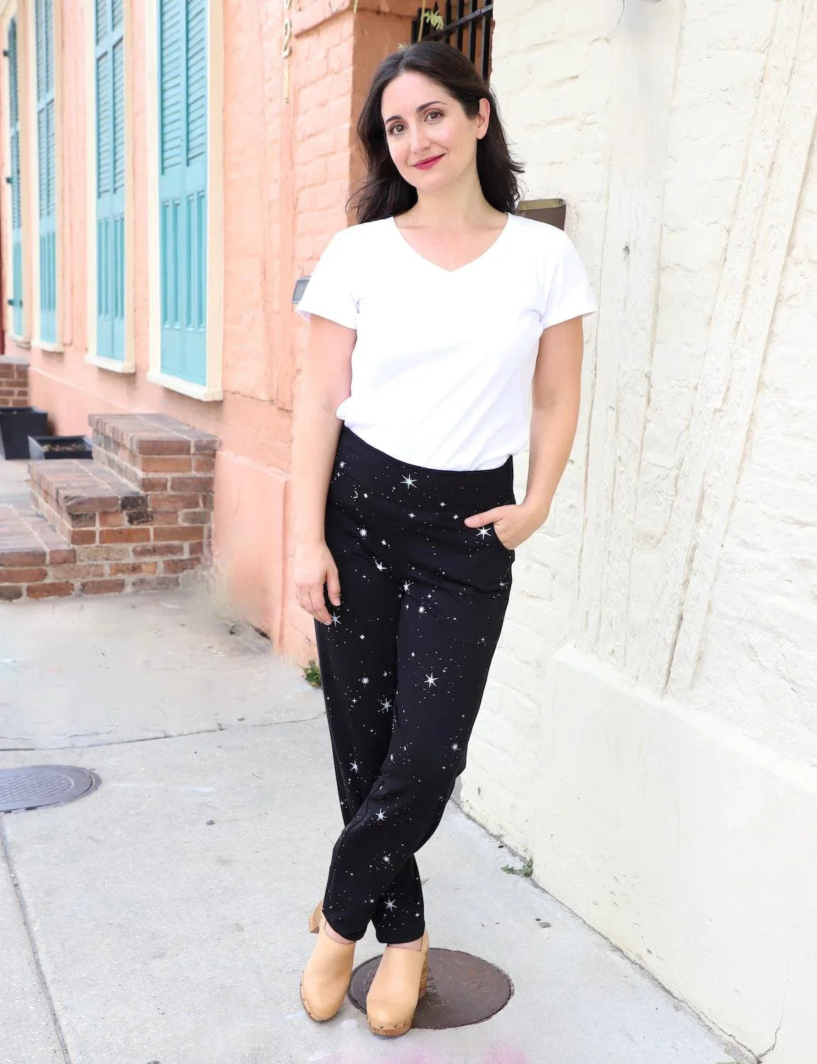 Woman in white tee and starry black organic pants, eco fashion by Qu!rk Boutique, sidewalk scene