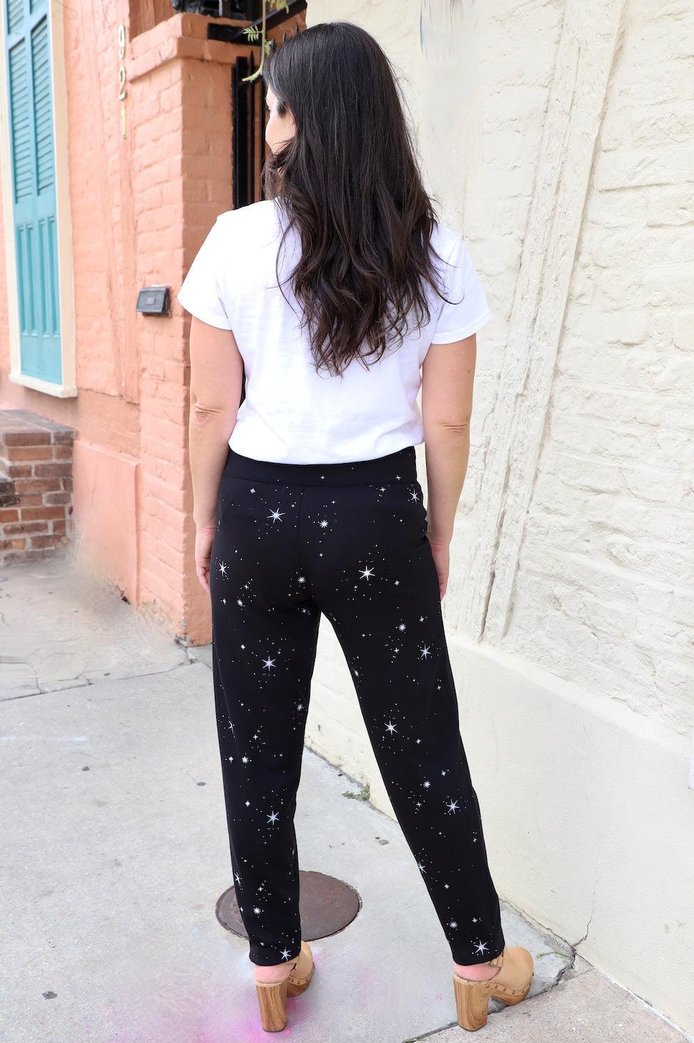 Woman in white tee and black starry print organic pants standing outdoors, Qu!rk Boutique