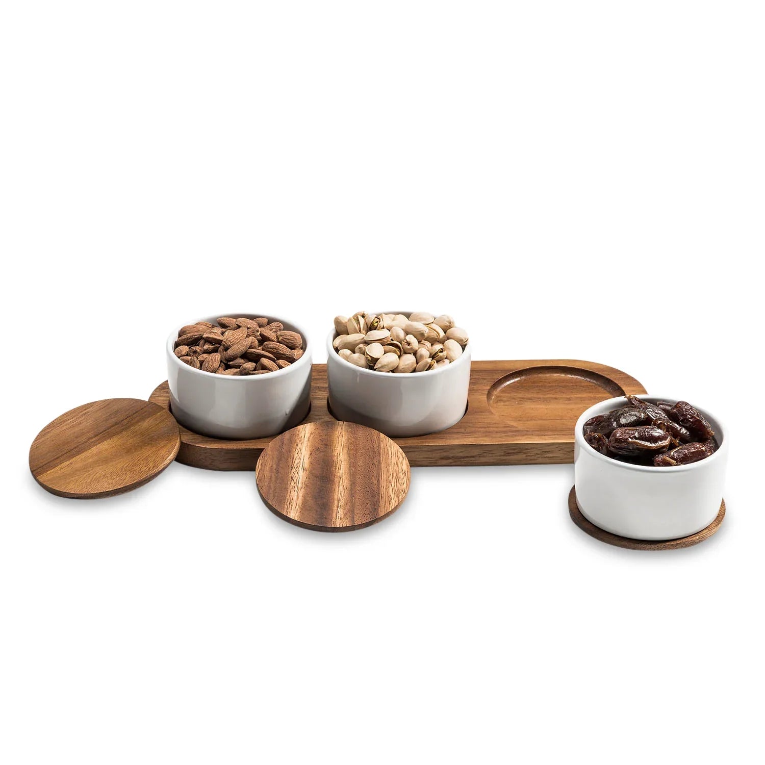 Modern ceramic snack bowls with wooden lids and tray, filled with almonds, pistachios, and dates