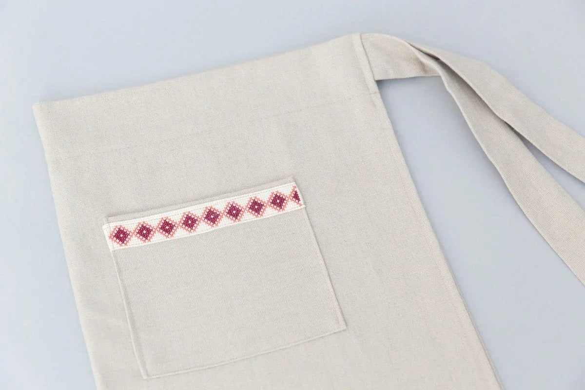 Cream Tatreez apron with front pocket and embroidered pink geometric trim, Qu!rk boutique gift