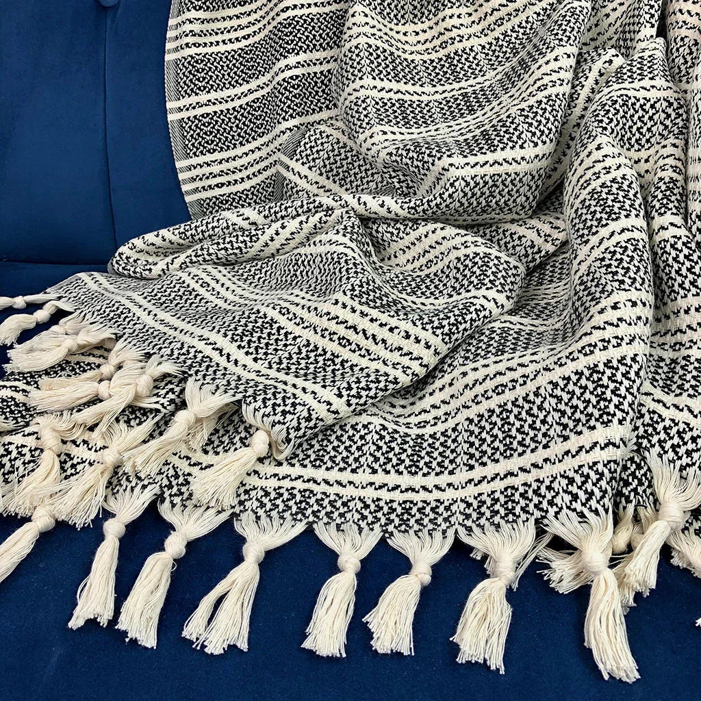 Black and cream Turkish throw blanket with woven pattern and tassels on blue sofa, Qu!rk Boutique