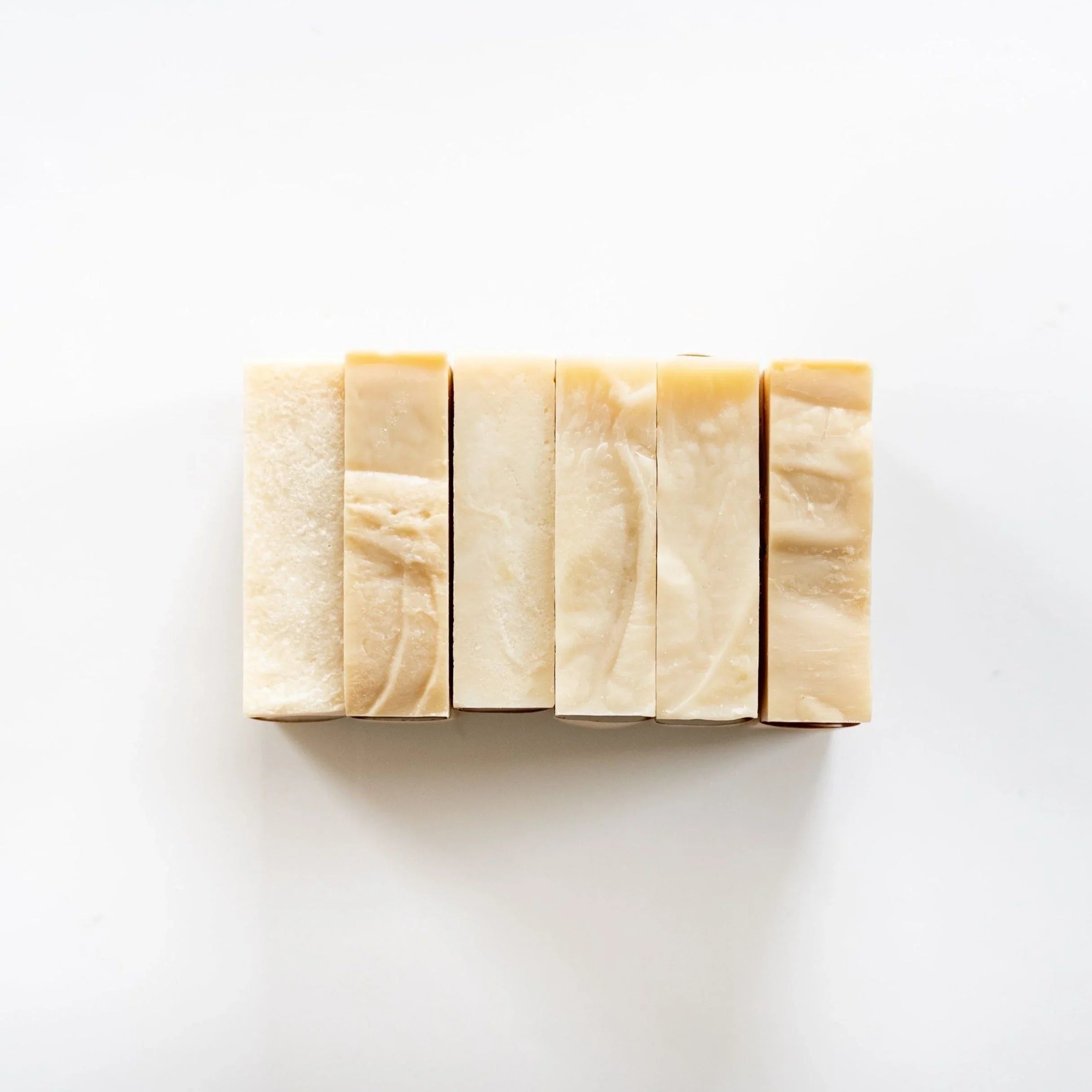 Handmade natural soap bars arranged in a row on a white background, Qu!rk Boutique