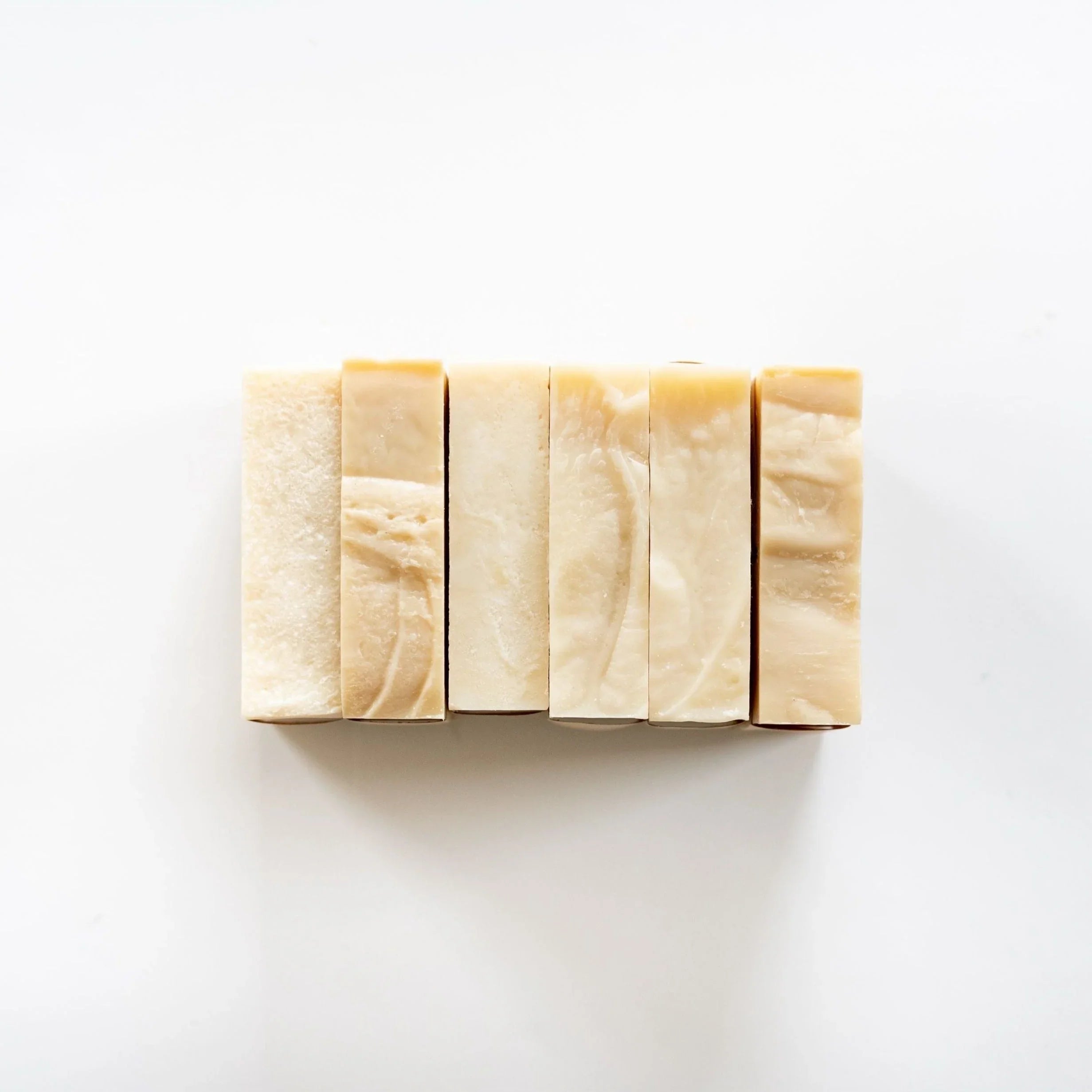Six handmade natural soap bars lined up on a white background, sustainable gift idea at Qu!rk Boutique