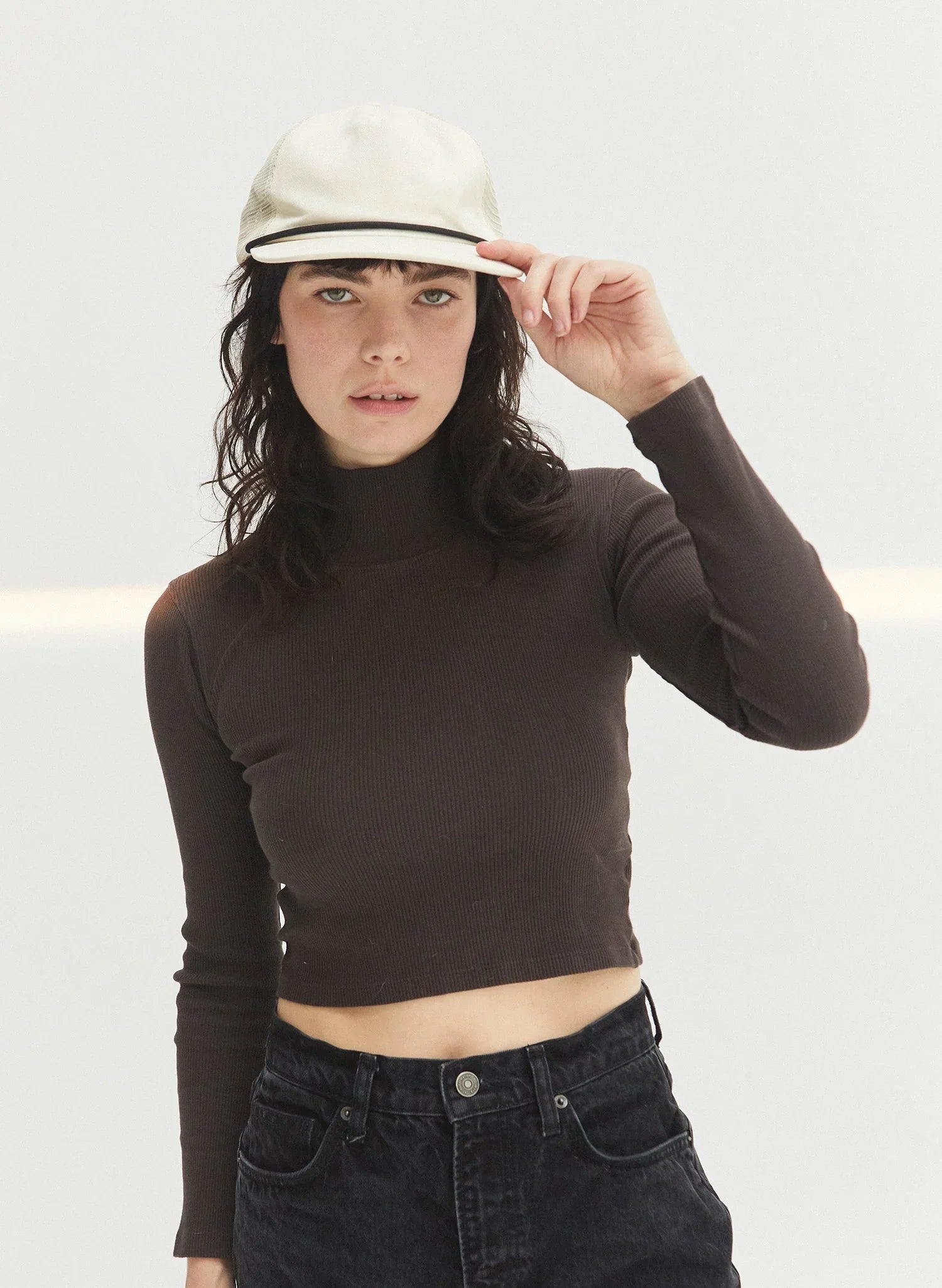 Woman in eggshell brushed cotton rope trucker hat and dark crop top, Qu!rk Boutique
