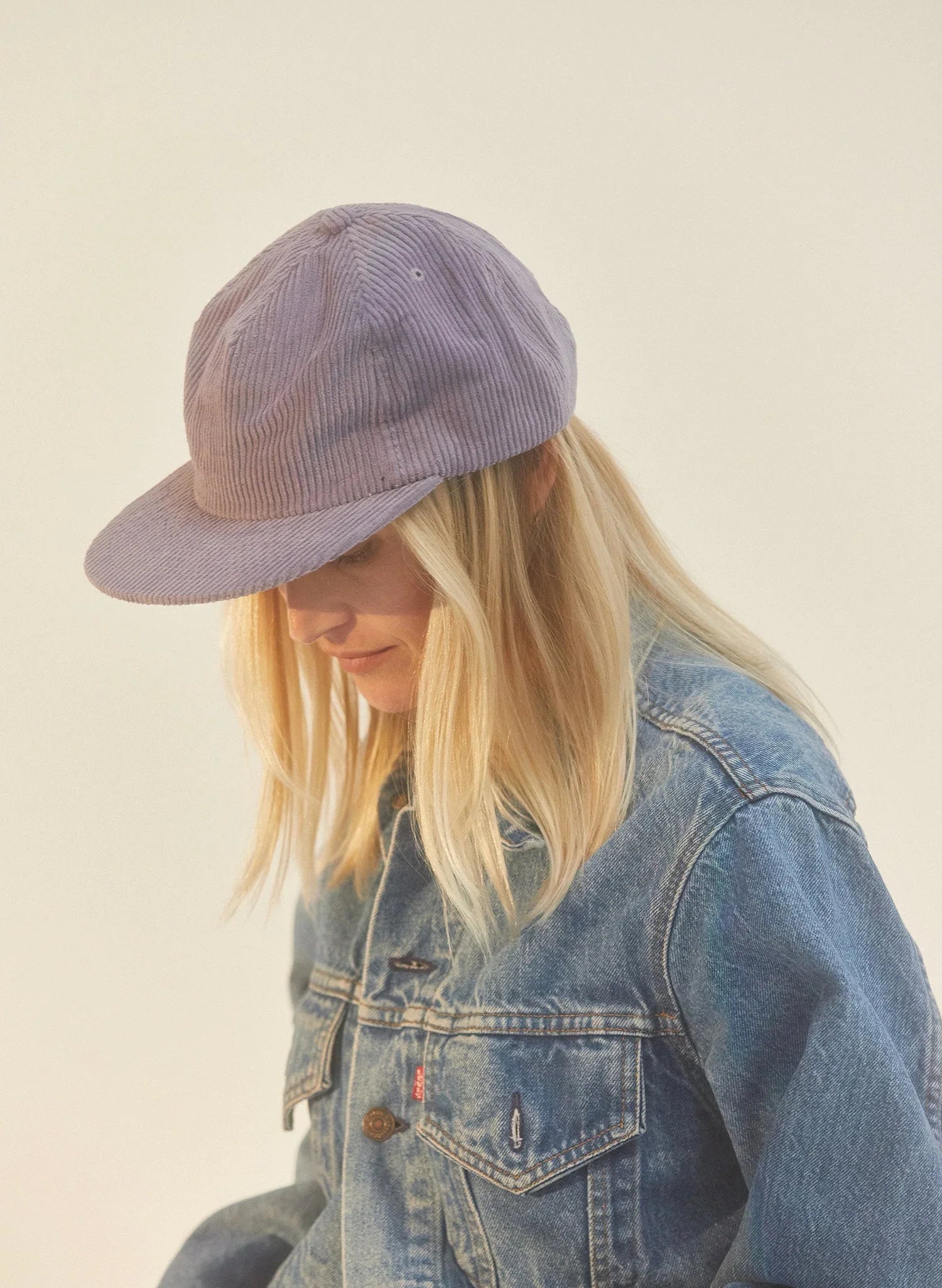 Woman in a moonstone corduroy field trip hat and denim jacket, Qu!rk Boutique fashion