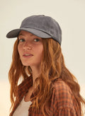 Woman wearing vintage black washed dad hat, brown plaid shirt, and white tee, Qu!rk Boutique