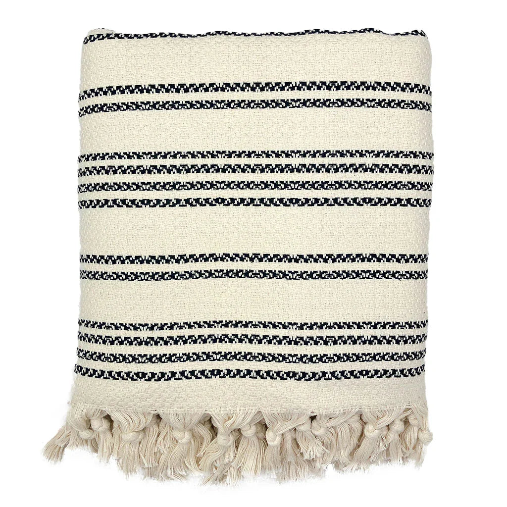 Folded woven stripe throw blanket with black and cream patterns and fringe, Qu!rk Boutique.