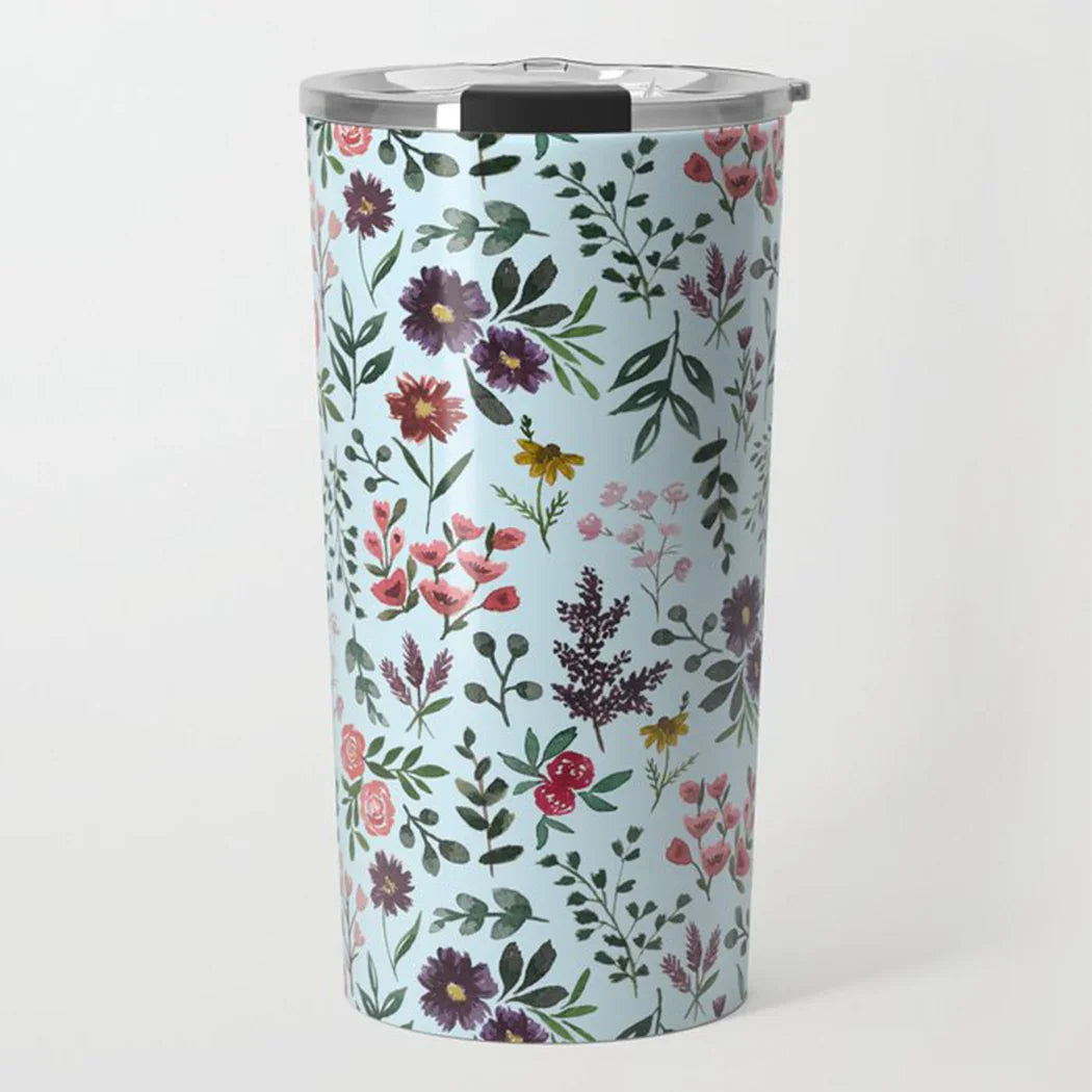 Stainless steel travel tumbler with colorful floral pattern on light blue background