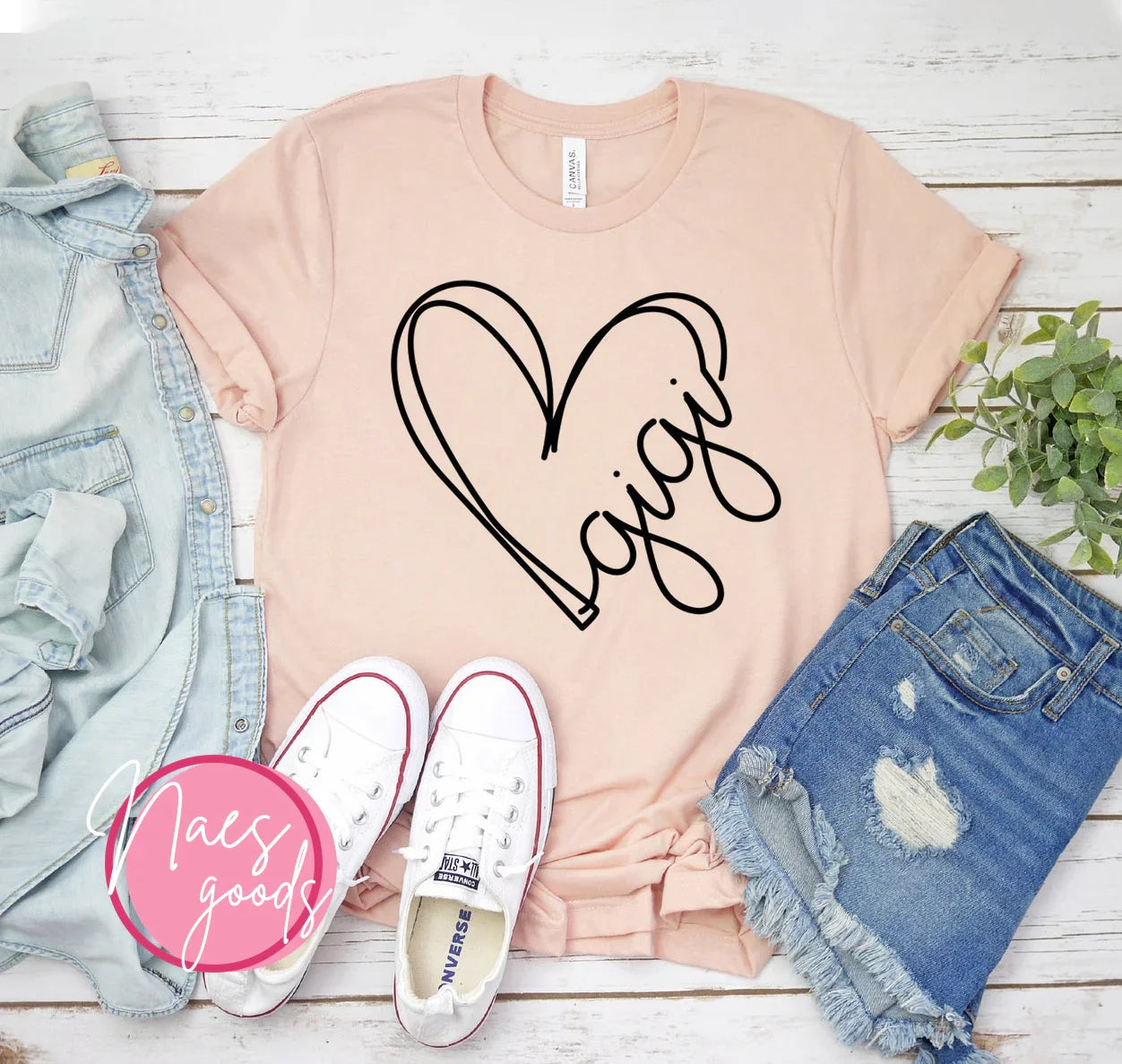 Light pink T-shirt with black heart and 'gigi' text, paired with denim shorts, white sneakers, and light denim jacket