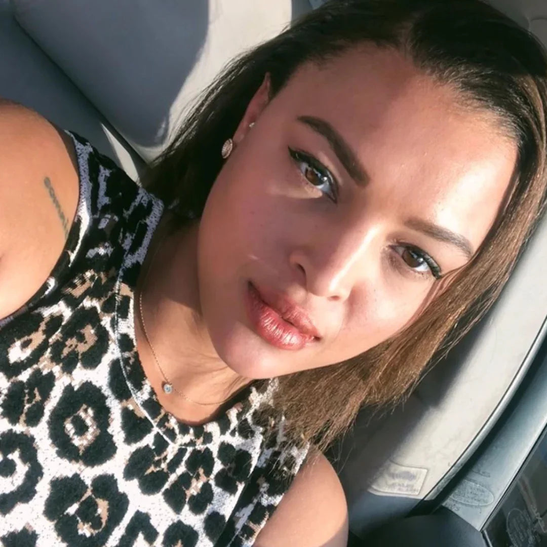 Woman in a car wearing a leopard print top, showcasing bold, artistic boutique style