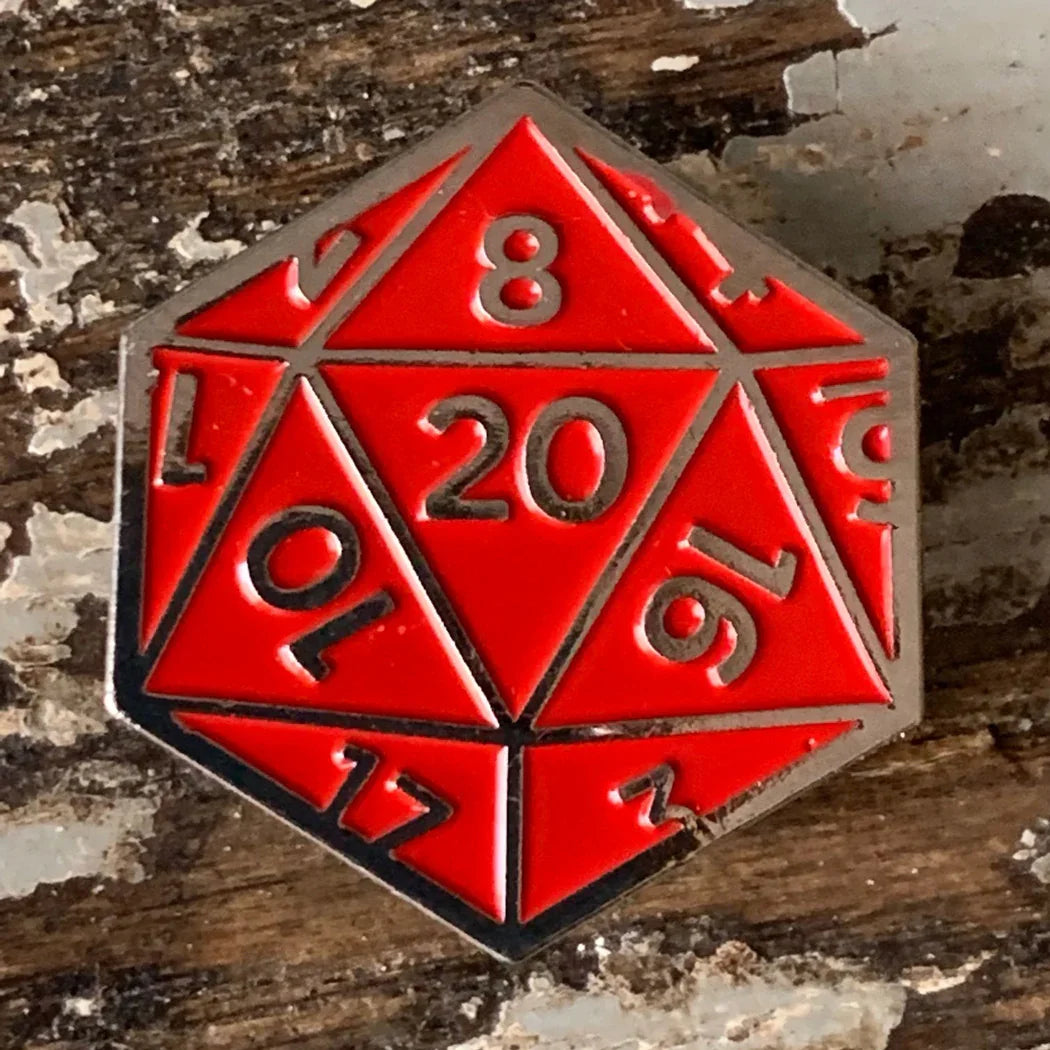 Red D20 enamel pin on rustic wood, Qu!rk Boutique artist-designed accessory