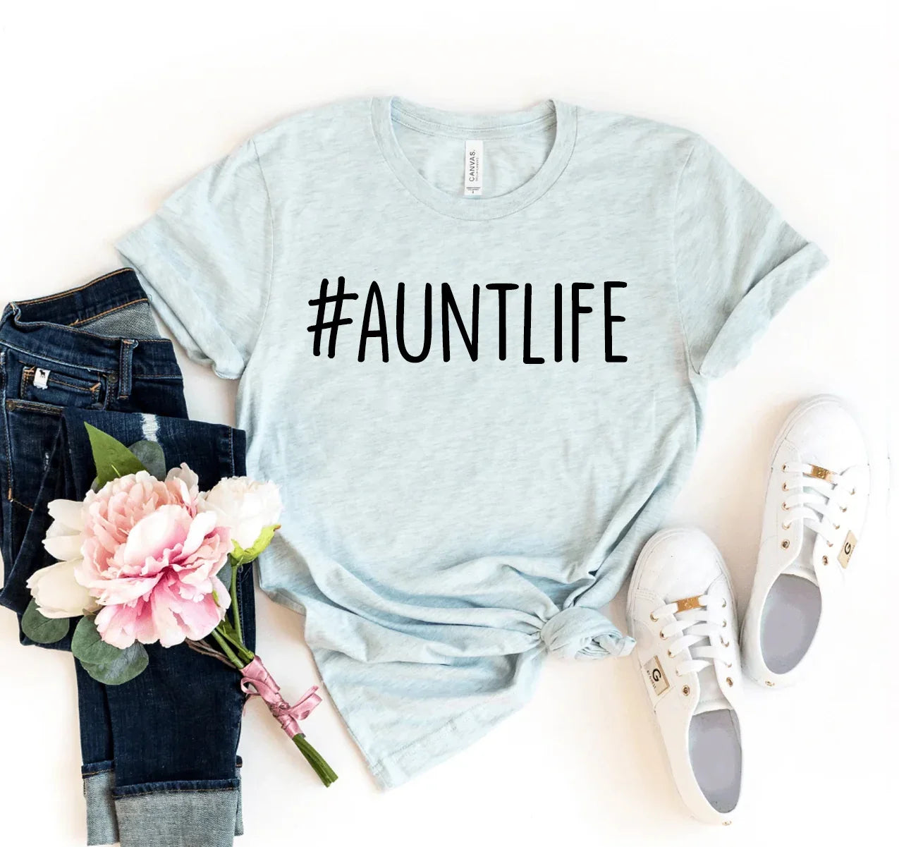 Light gray t-shirt with #AUNTLIFE print, paired with blue jeans, pink flowers, and white sneakers